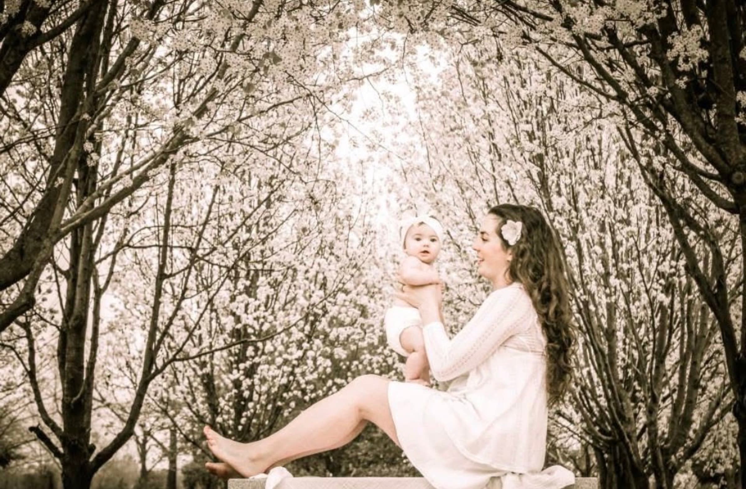 A parent and child beneath flowering trees