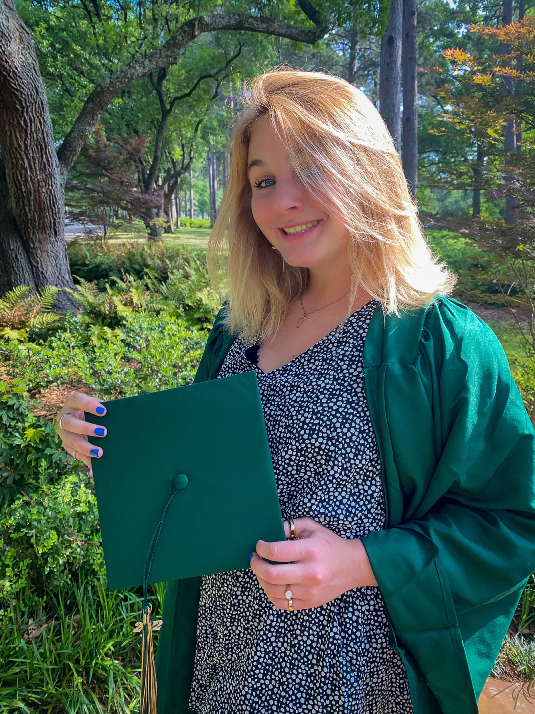Graduate holding a diploma outdoors
