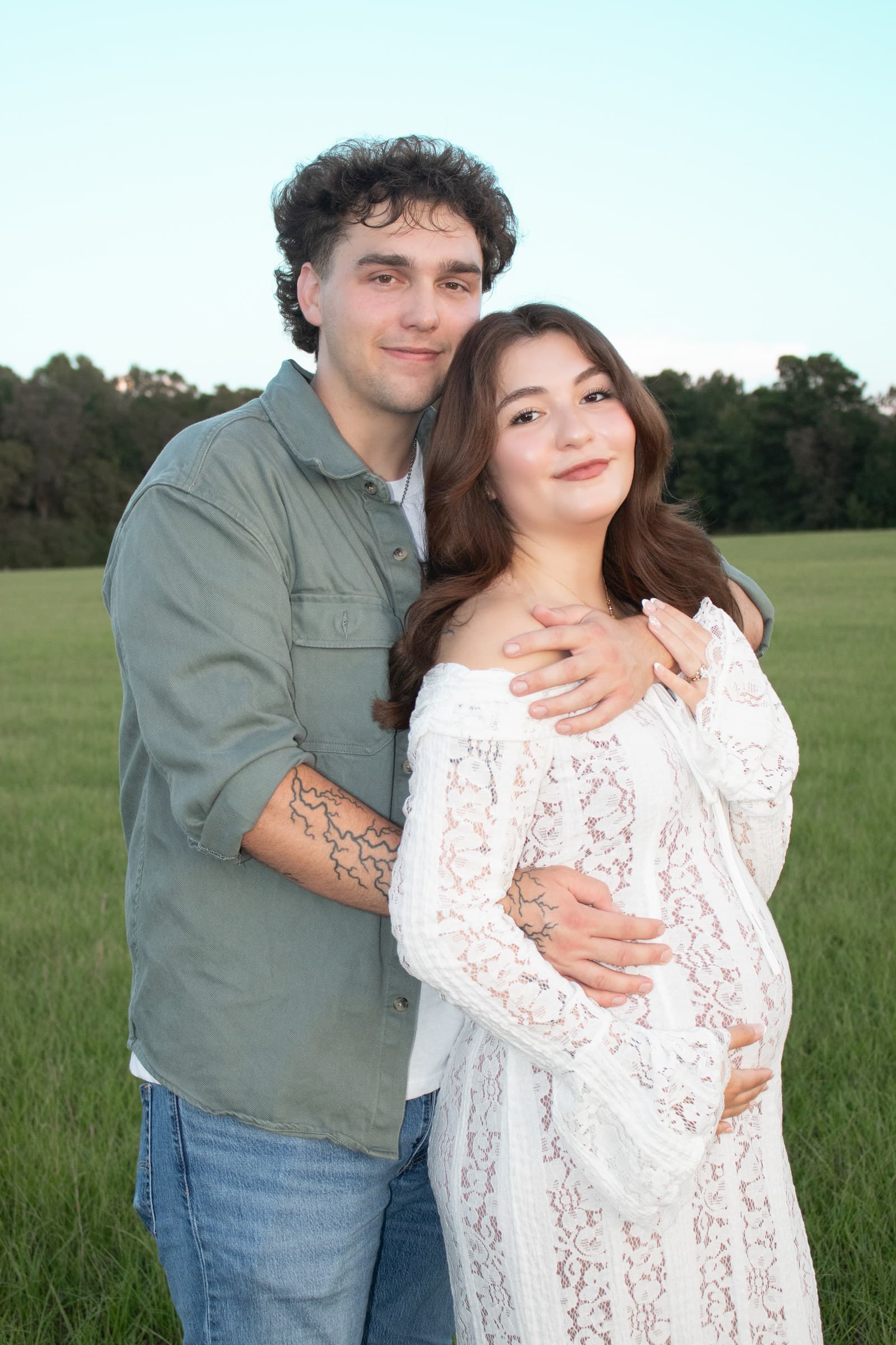 Expecting mother and partner embracing outdoors