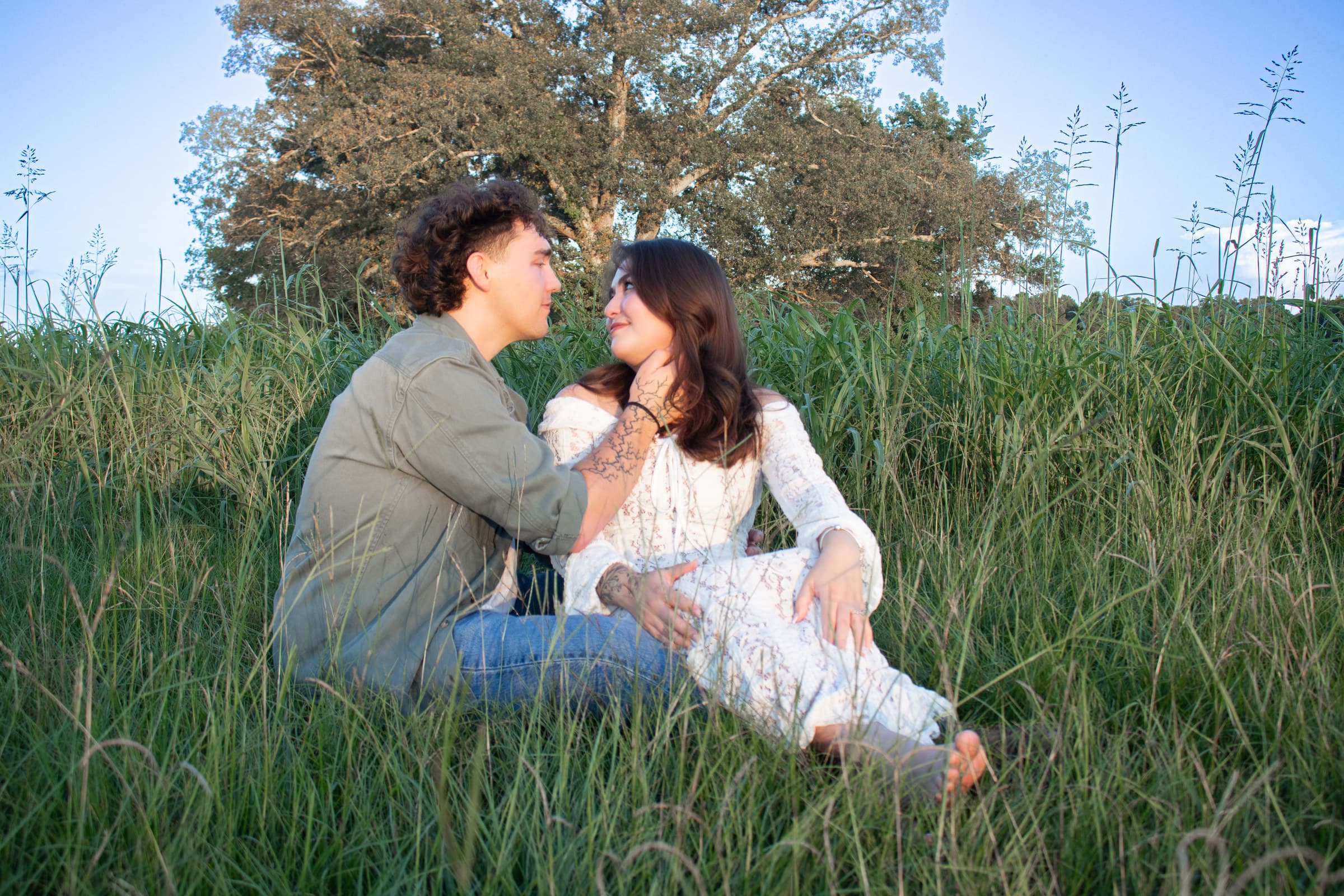 Maternity couple seated together in a field