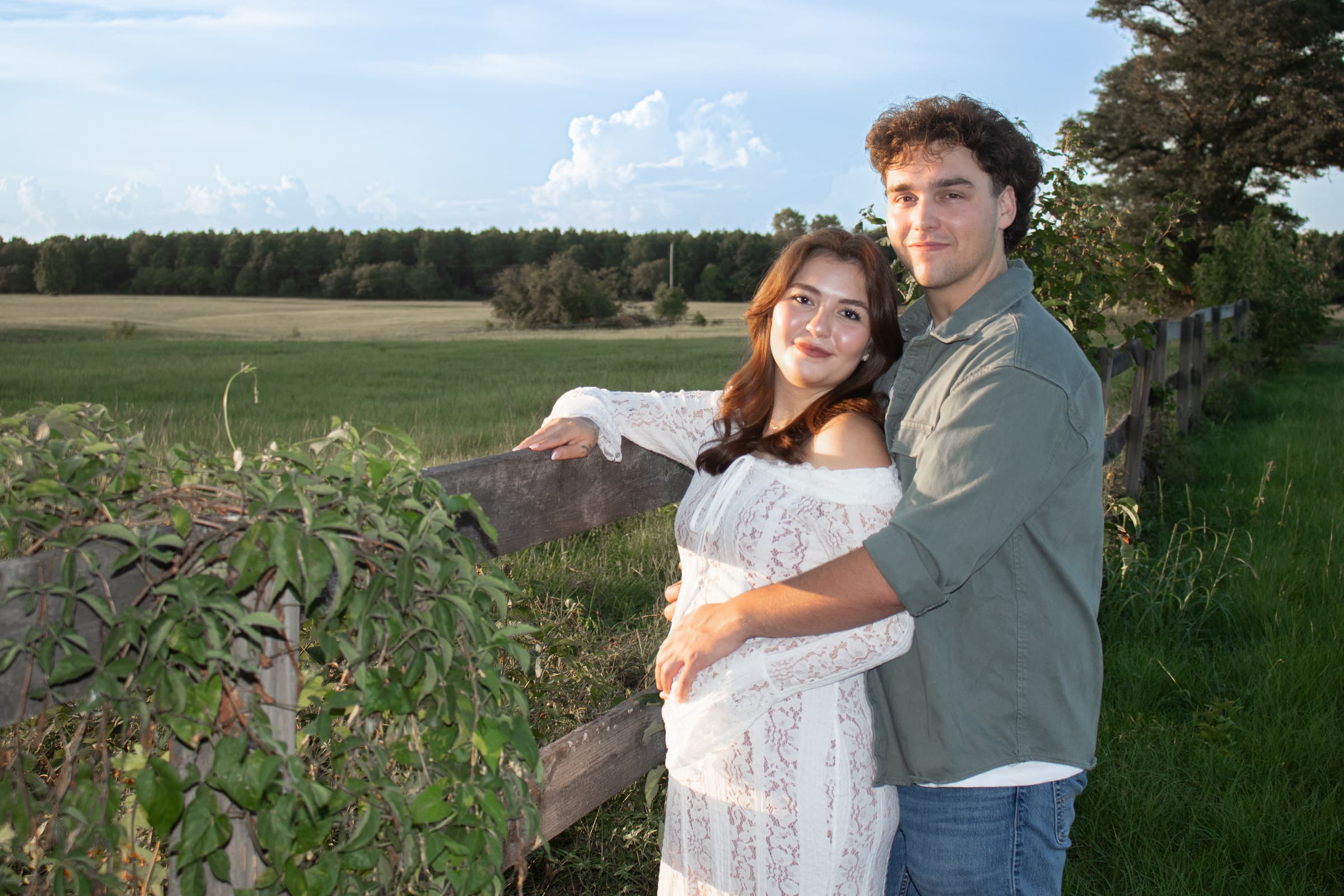Expecting couple holding each other in an open field