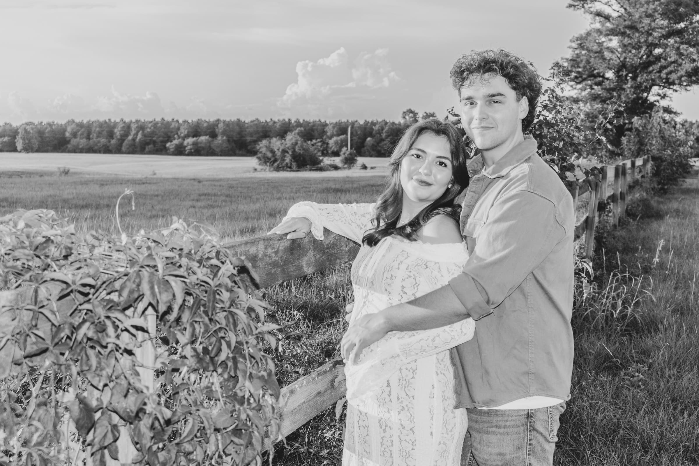 Black-and-white maternity portrait in a field
